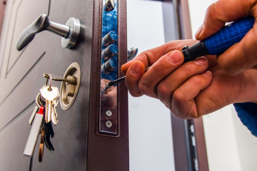 Un technicien visse les composants lors de l'opération pour installer un verrou de porte blindée